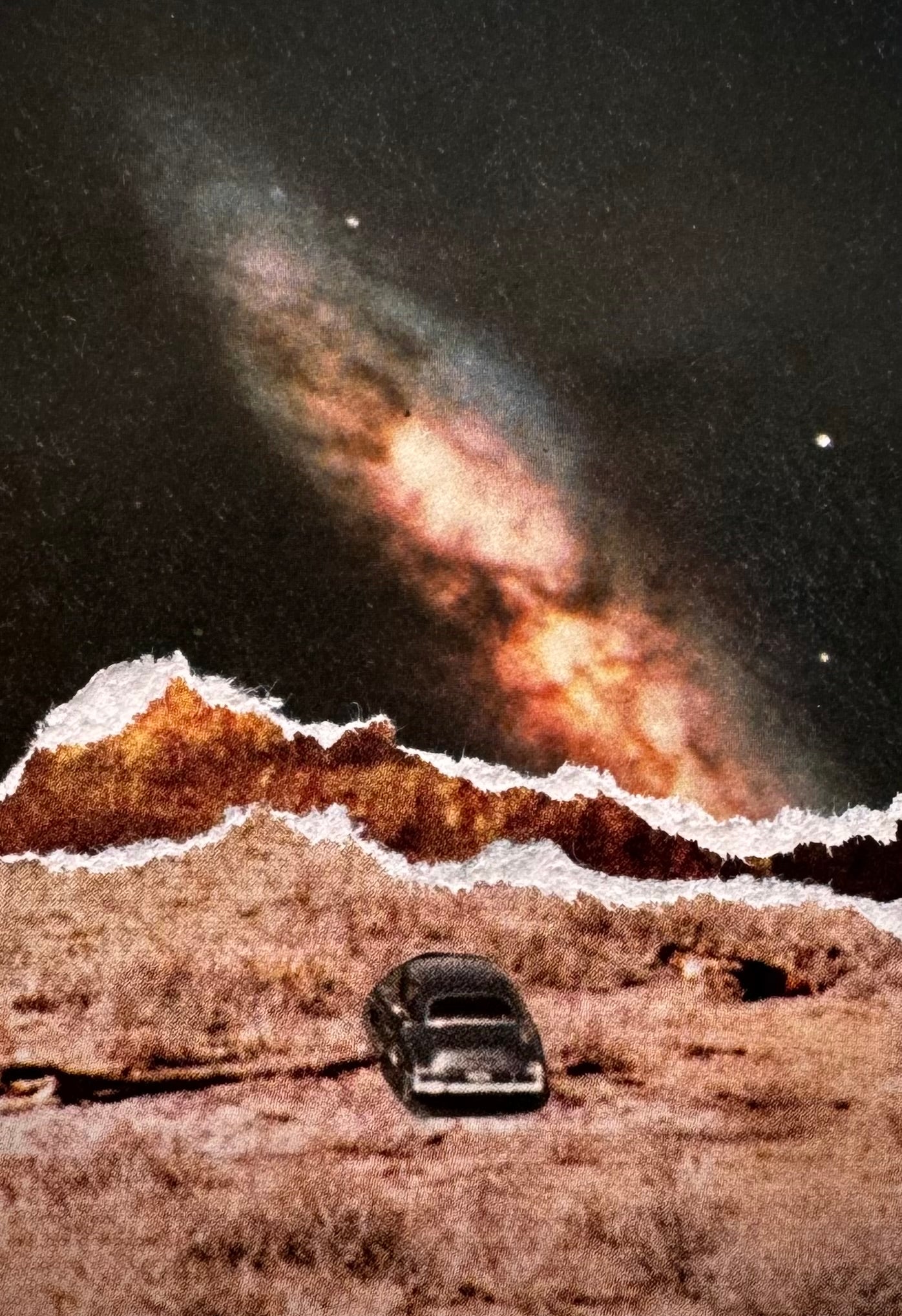 Collage of a car on a desert landscape with a large celestial object resembling a galaxy in the sky.